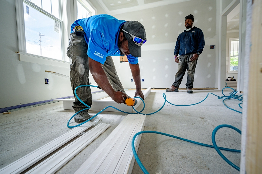 Construction crew measuring inside a home renovation